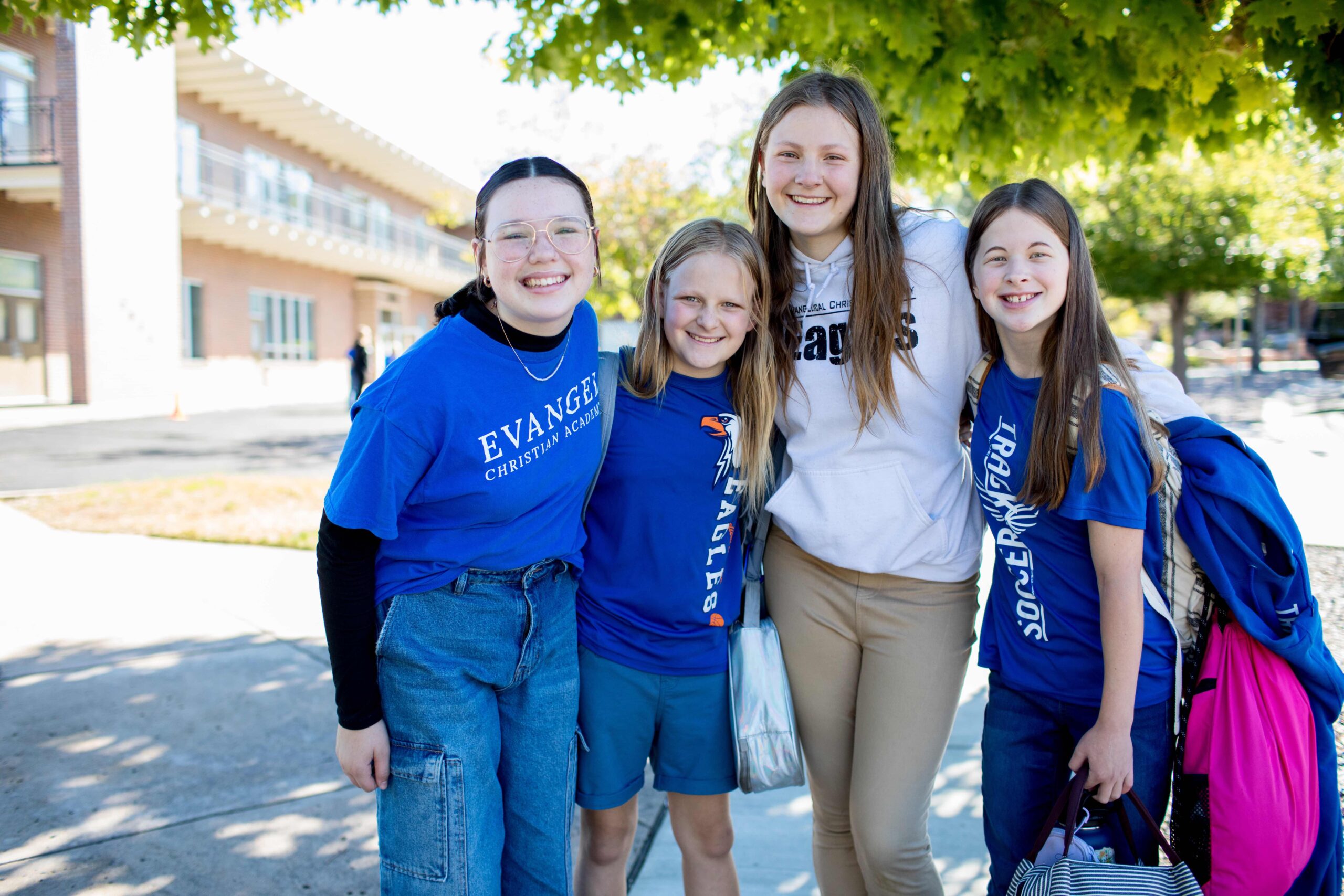 Four middle school girls standing together outside 