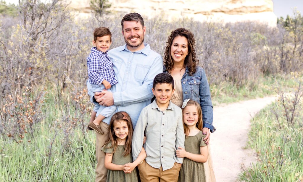 A family of six standing together outdoors